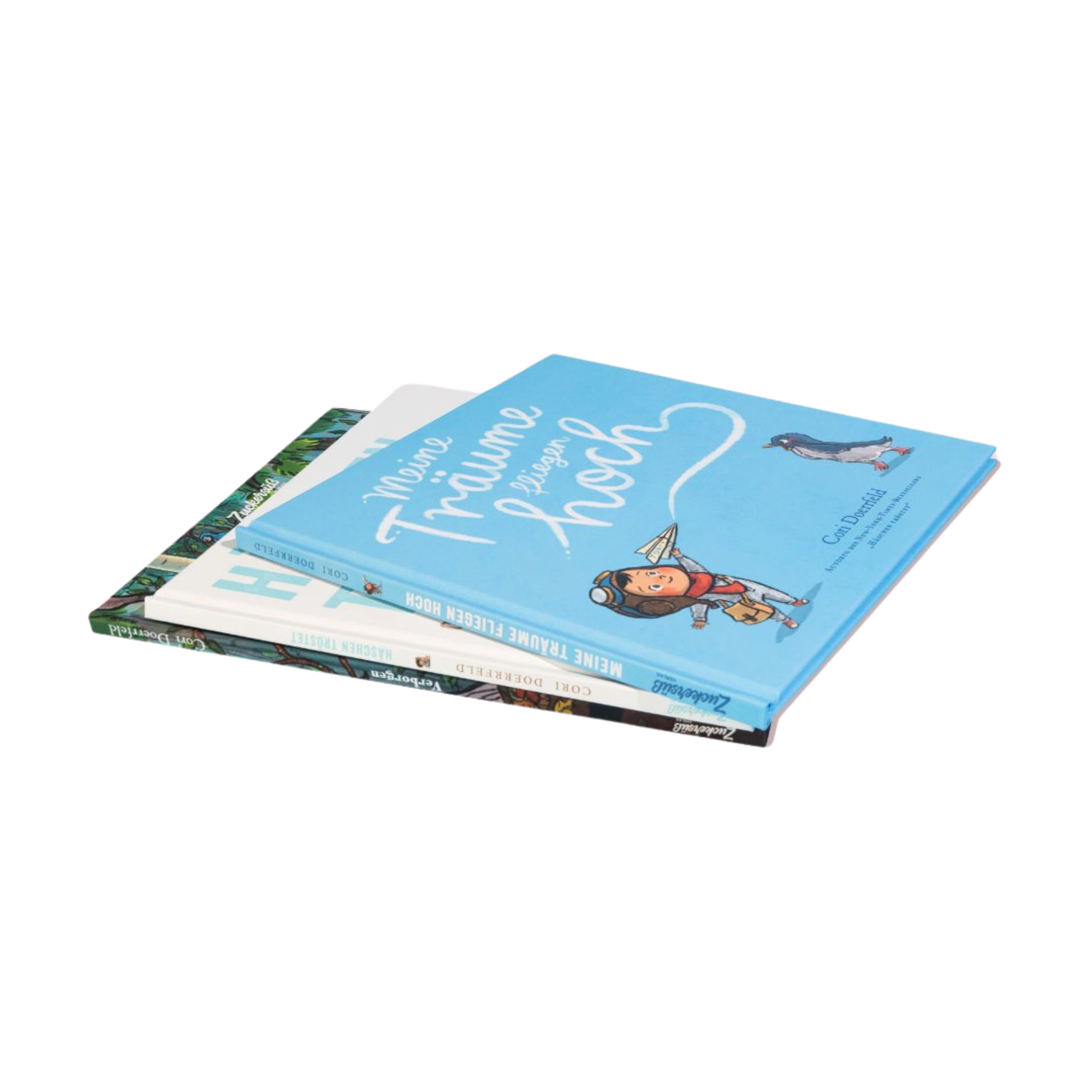 Drei „Best of Cori Doerrfeld“-Kinderbücher des Zuckersüß Verlags liegen auf einer weißen Fläche; das oberste Buch, "Meine Träume fliegen hoch" zeigt einen blauen Einband mit einer Kinder- und Pinguin-Illustration.