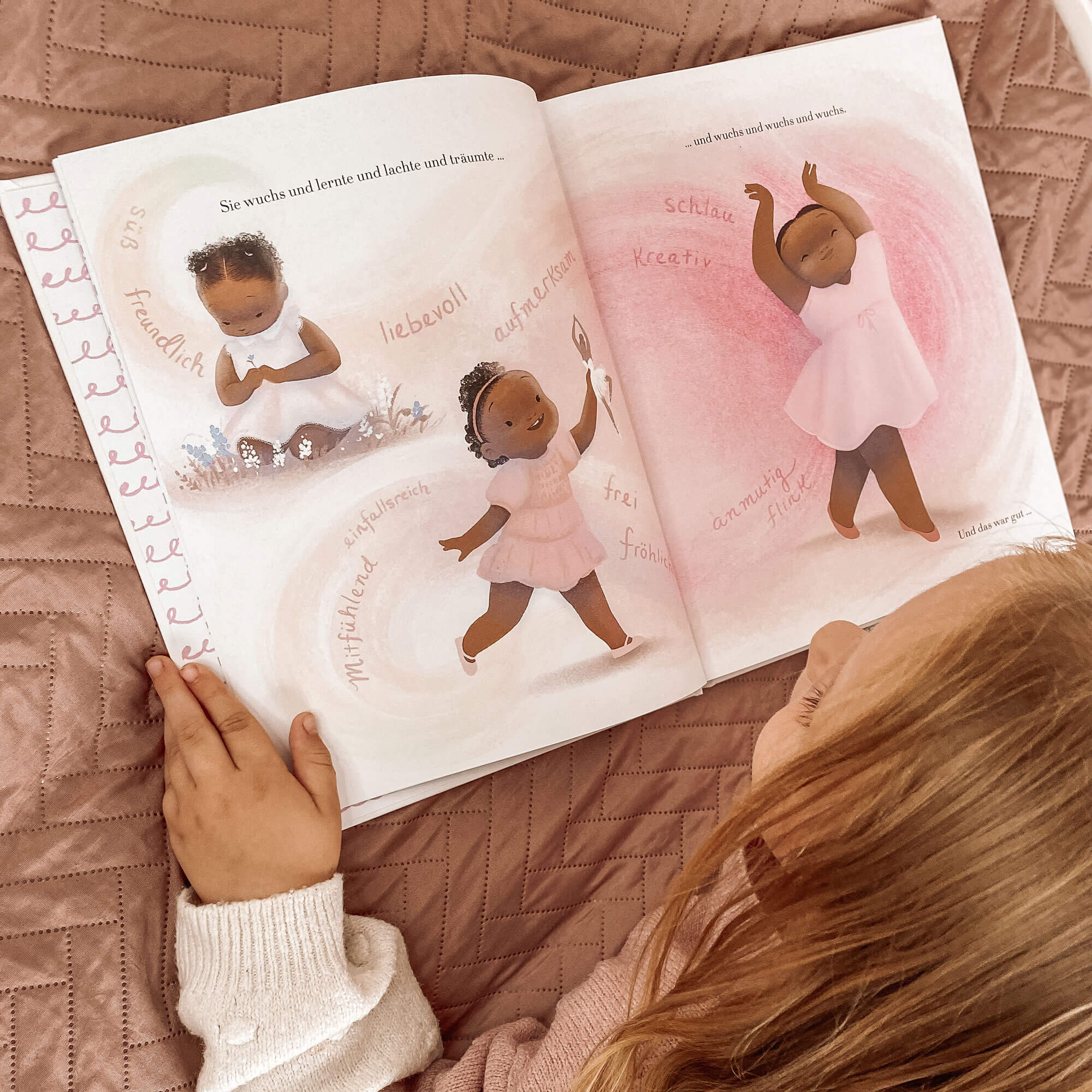 Ein kleines Kind im Kinderzimmer liest "Best of Vashti Harrison" aus dem Zuckersüß Verlag und erfreut sich an den bezaubernden Illustrationen eines schwarzen Mädchens, das in farbenfrohen Kleidern tanzt, begleitet von aufmunternden deutschen Worten.