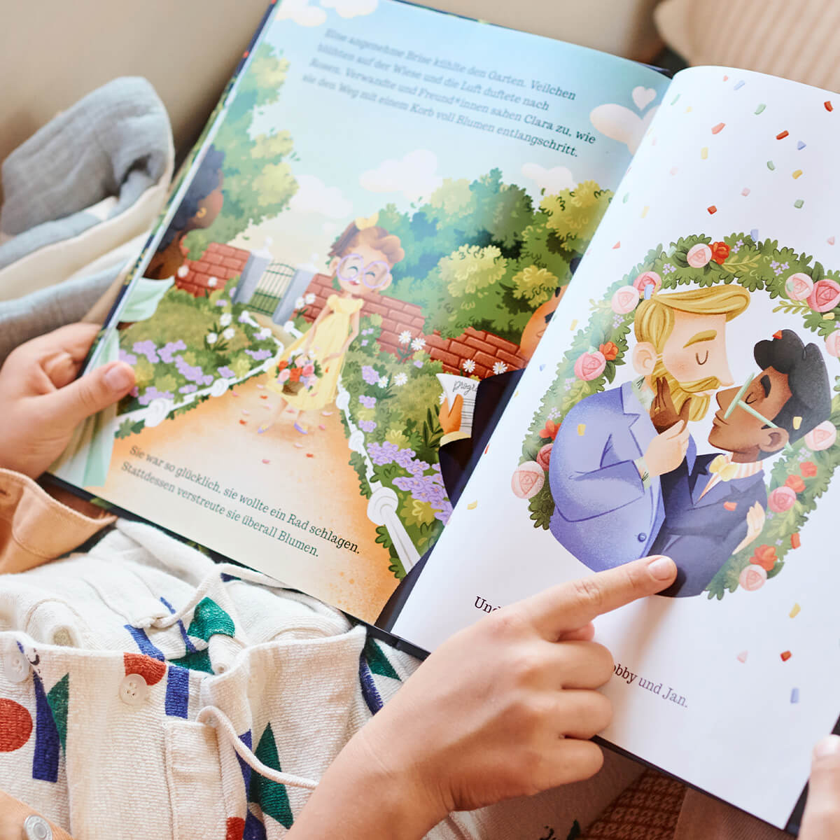 Ein Kind liest "Onkel Bobbys Hochzeit" von Sarah S. Brannen, mit einer Illustration von zwei Personen in Anzügen, die von einem Blumenkranz umgeben sind und sich gerade küssen, und einer weiteren Seite mit einem Kind, das einen Gartenweg entlanggeht.