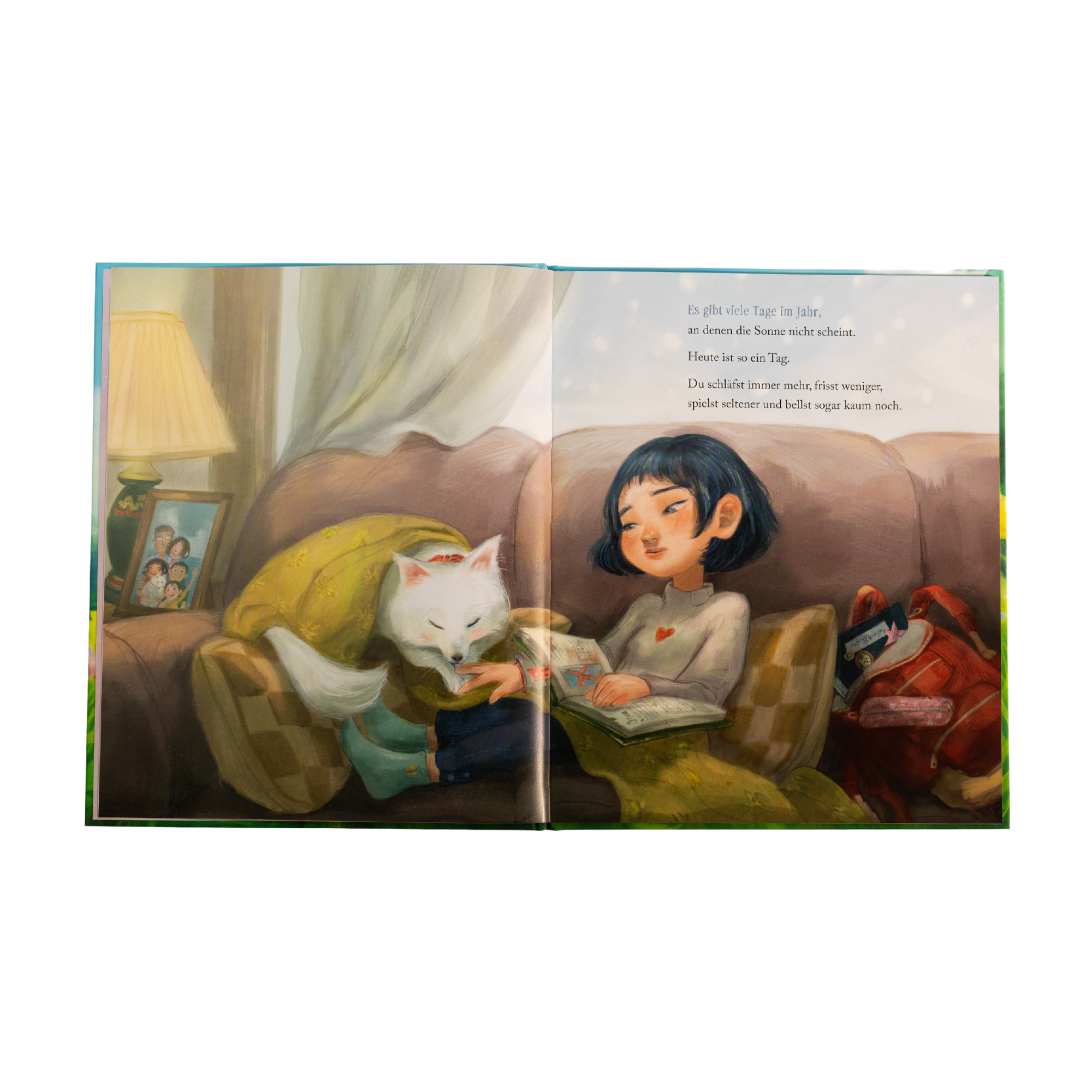 Eine Illustration aus "Für immer in meinem Herzen" von Kelly Wu zeigt ein Mädchen mit kurzen dunklen Haaren, das auf einer Couch neben einem flauschigen weißen Hund liest. Beide sind in eine Decke eingewickelt.