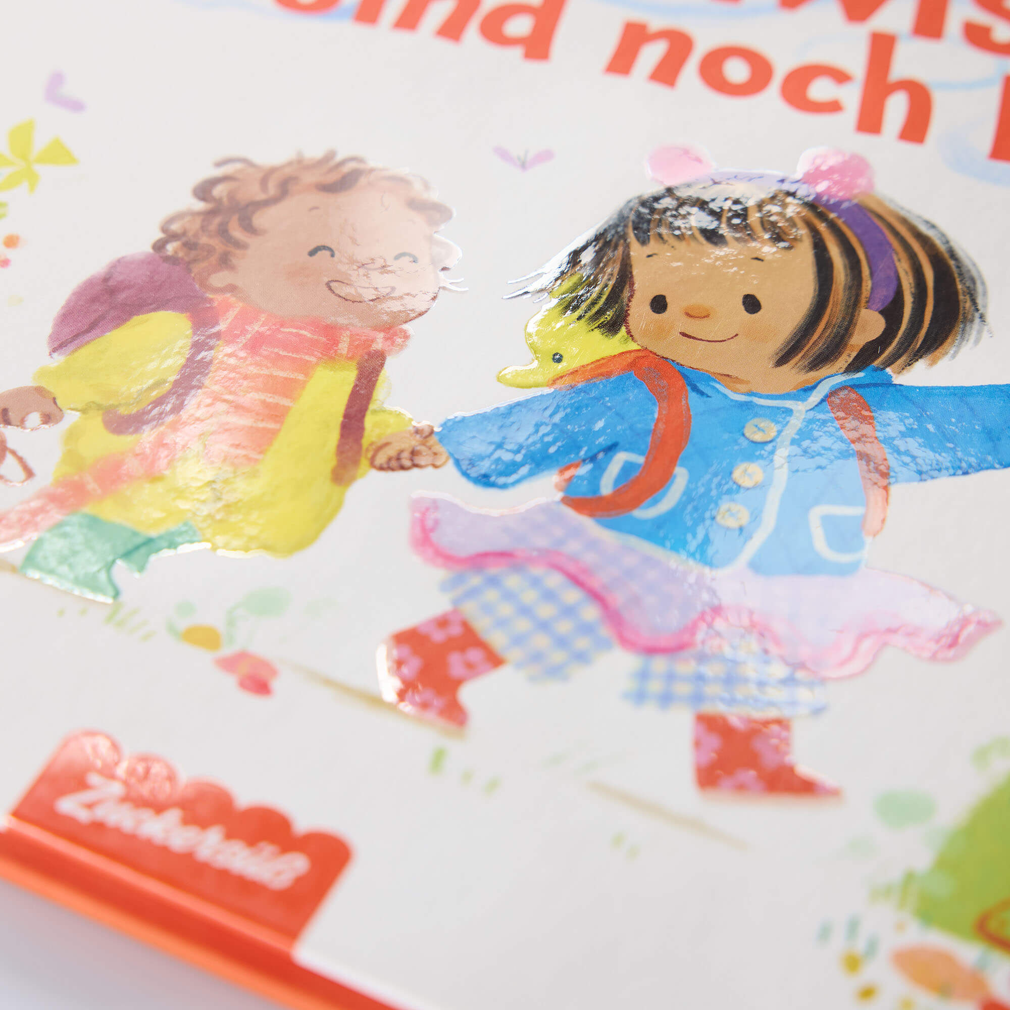 Umschlagillustration von zwei lächelnden Kindern in bunter Kleidung mit Rucksäcken, die sich an den Händen halten. Der Buchtitel 