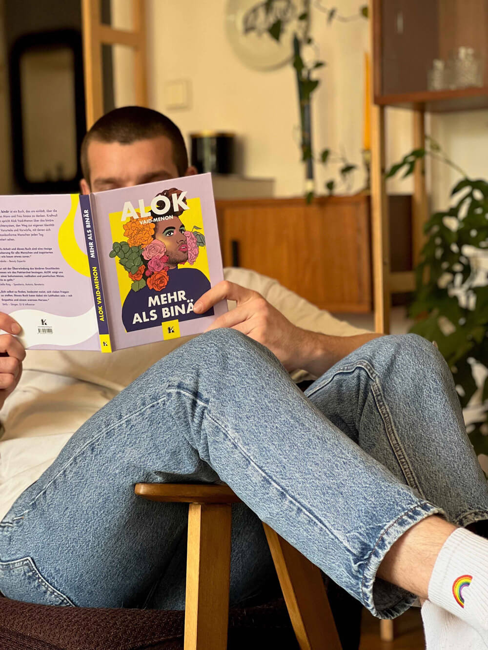 Eine Person entspannt sich mit gekreuzten Beinen und liest 