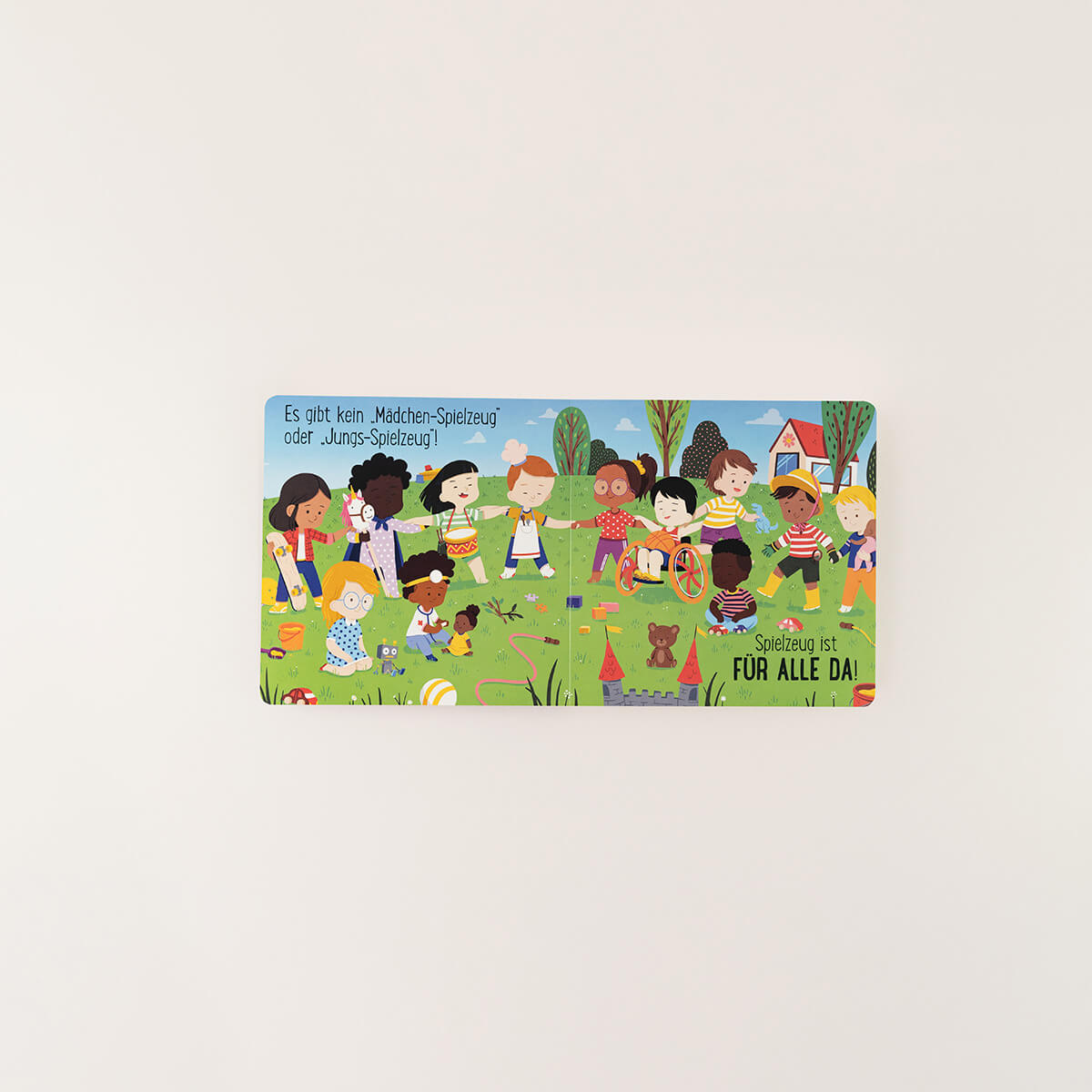 Eine illustrierte Buchseite vom Zuckersüß Verlag zeigt Kinder beim Spielen und betont: "Spielzeug ist für alle da & Kleidung ist für alle da" - es gibt kein typisches Jungs- oder Mädchenspielzeug, jedes Kind darf alles nutzen!.