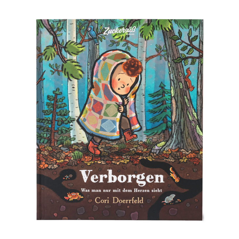 Das Cover des Bilderbuchs „Verborgen“ von Cori Doerrfeld zeigt ein Kind, das in eine bunte Patchwork-Decke gehüllt durch einen herbstlichen Wald läuft. Umgeben von Bäumen, Laub und Waldtieren entsteht eine einfühlsame Szene. Unter dem Titel steht der Satz „Was man nur mit dem Herzen sieht“.
